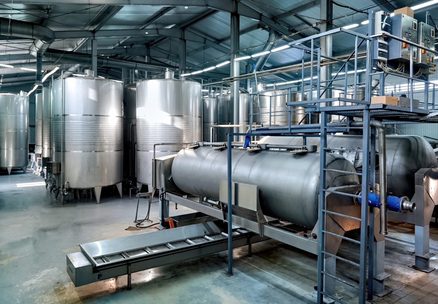 Metal wine storage tanks in a winery. Wide shot